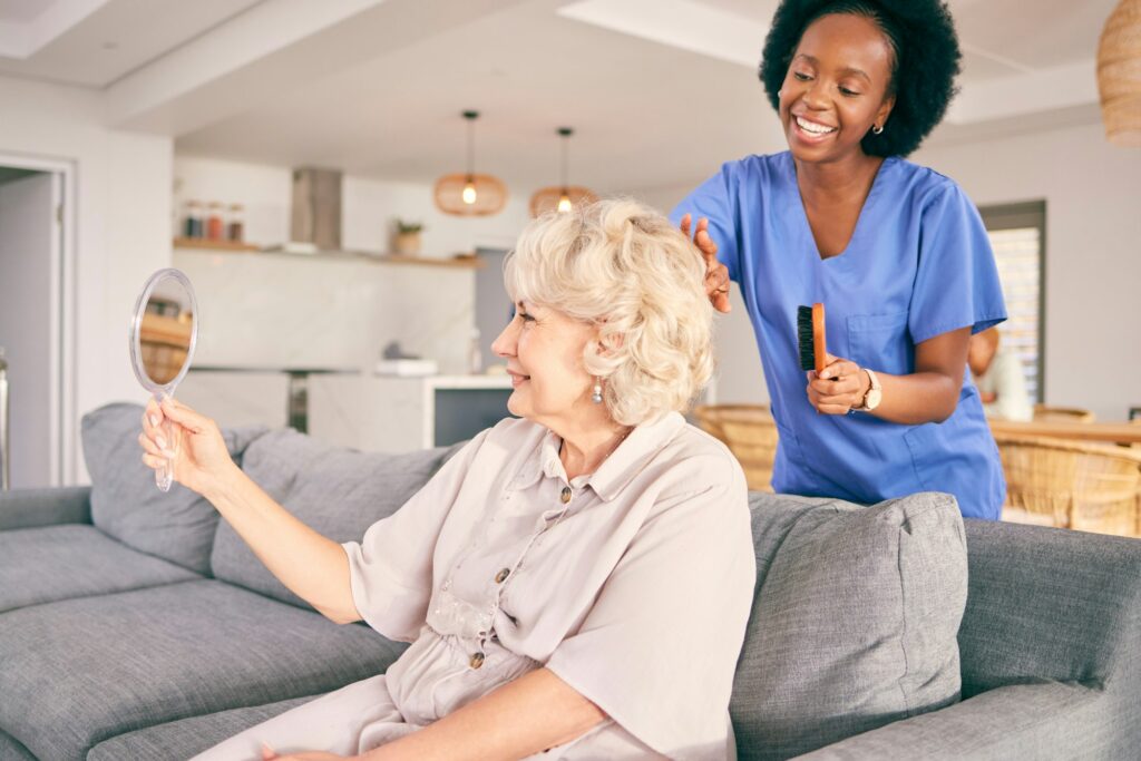 Caregiver brush hair of senior woman in the living room of the modern retirement home for self care
