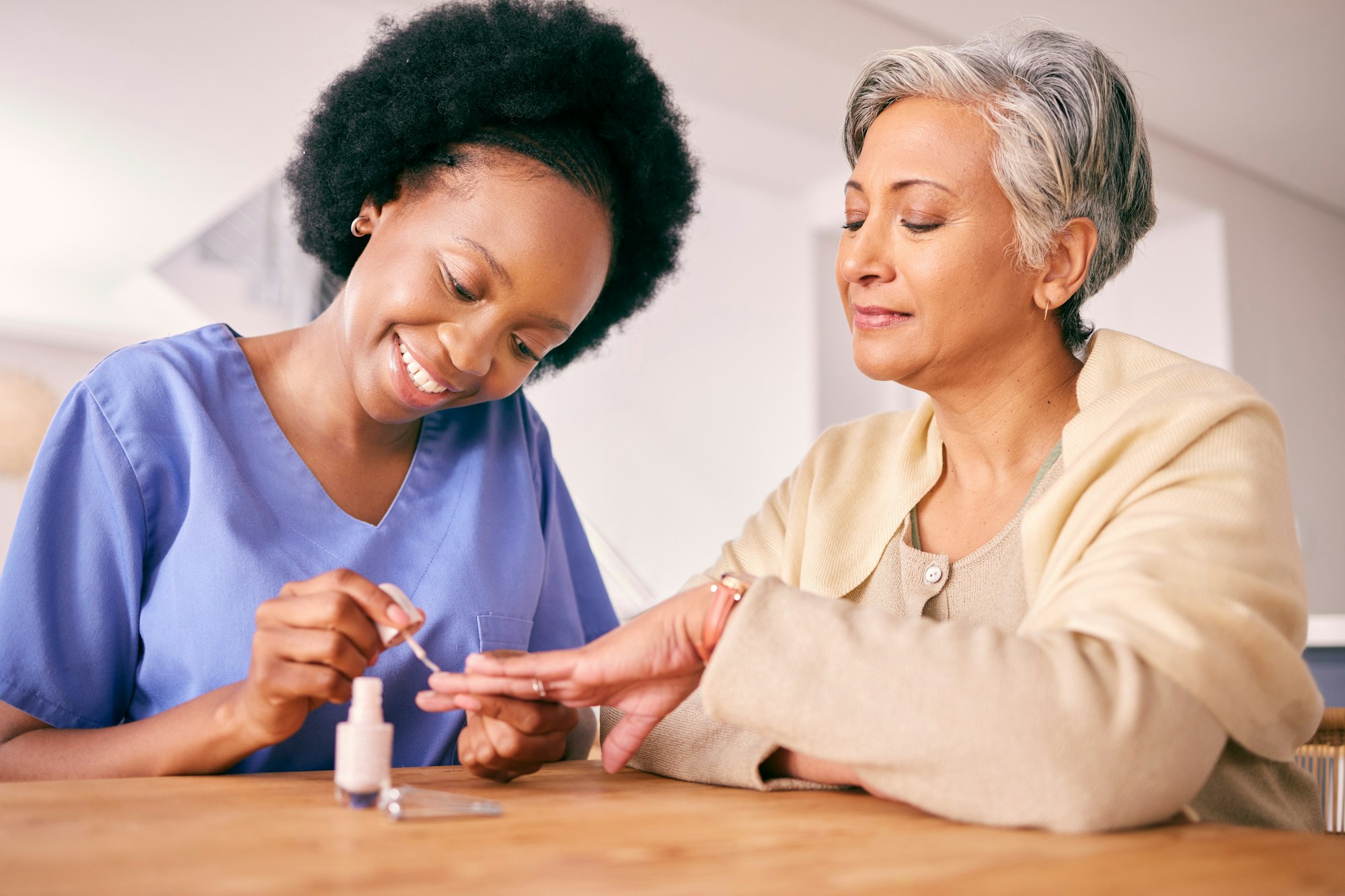 Nursing home, manicure and a caregiver with a senior woman for a grooming or beauty treatment. Happ